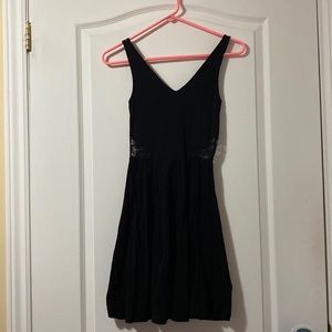 Black mini dress with lace back and lace side detail.
